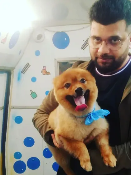 A happy pet parent with his equally happy Pomeranian. We love capturing these joyful moments.