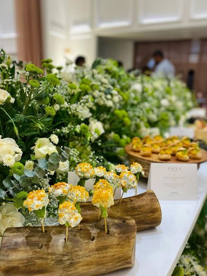An elegant canapé station at the Zoya Jewels flagship store launch in Hyderabad. The pristine white floral arrangements create a luxurious backdrop for our culinary art.