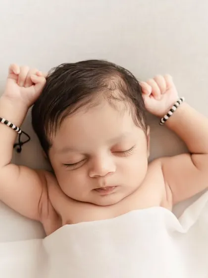 A peaceful portrait of a newborn stretching in their sleep, a simple and natural moment.