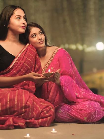 Looking up towards the light, this portrait of two friends captures a sense of hope and shared joy during the magical night of Dev Deepawali.
