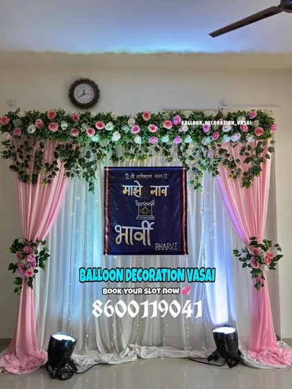A traditional Marathi naming ceremony (Barsa) backdrop. The setup includes elegant pink drapes, floral arrangements, and a custom banner in Marathi that says "Majhe Naam" (My Name) with the baby's name, Bharvi.