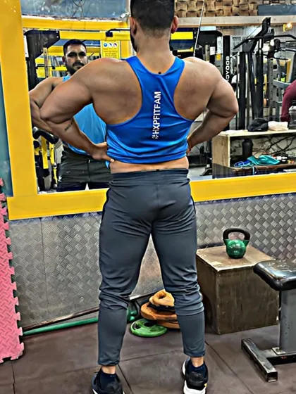 A lat spread pose, which emphasizes the width of the back. Exercises like wide-grip pull-ups and lat pulldowns are key for developing this V-taper.