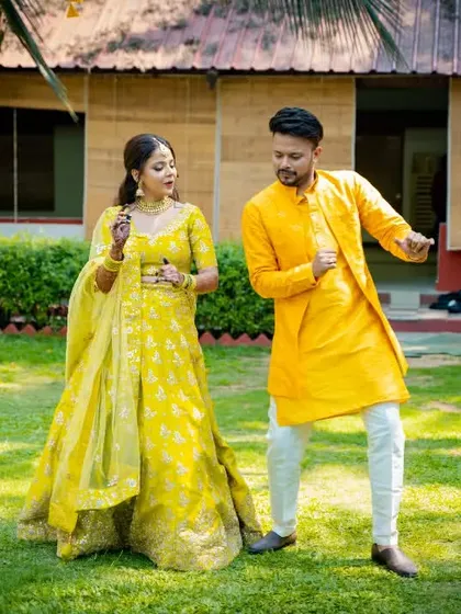 The Haldi ceremony is all about fun, and we are there to capture every bit of it. This candid shot shows a couple's playful dance, reflecting the vibrant energy and bright colors of the celebration.