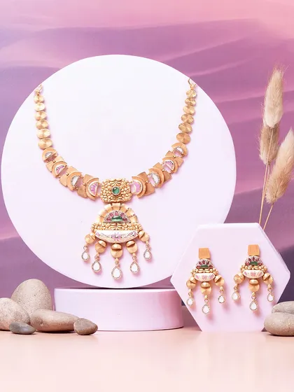 A play of curves, a fusion of form and elegance. This matte gold set features hammered textures and gemstone accents, creating a look that is both traditional and strikingly modern.