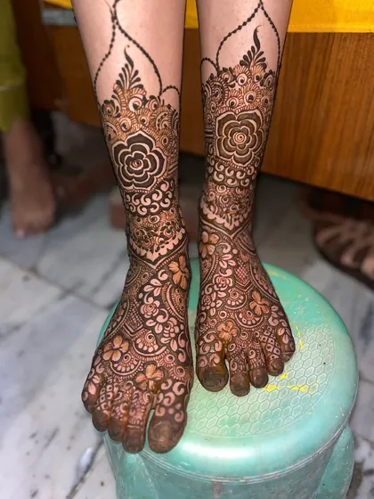 The detailed foot mehndi for bride Ayesha, designed to match her hand and arm patterns perfectly.