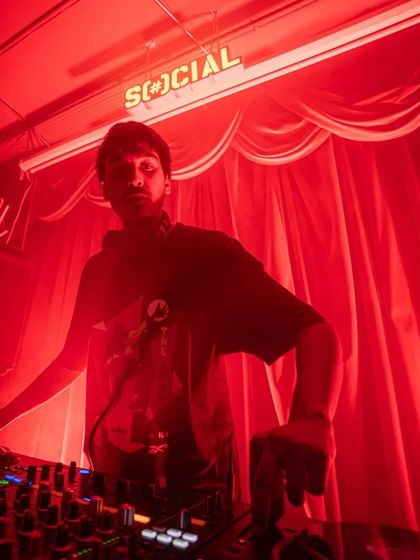 A shot of me at the decks during a hip hop bloc party, bathed in red light.