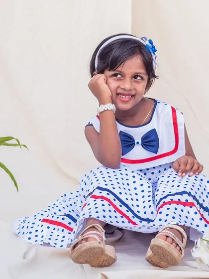 Capturing the fun of childhood in a dress made for smiles. This playful polka dot frock features a charming sailor-style collar with a navy bow, combining classic style with the comfort she needs for happy playdates and everyday adventures.