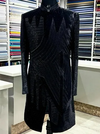 A different view of the black geometric sherwani, showing the full length and the way the patterns are arranged to create a slimming, modern silhouette.