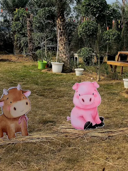 Cute cutouts of a calf and a piglet placed on hay in the garden area. These little touches help to create an immersive and playful environment for the children.