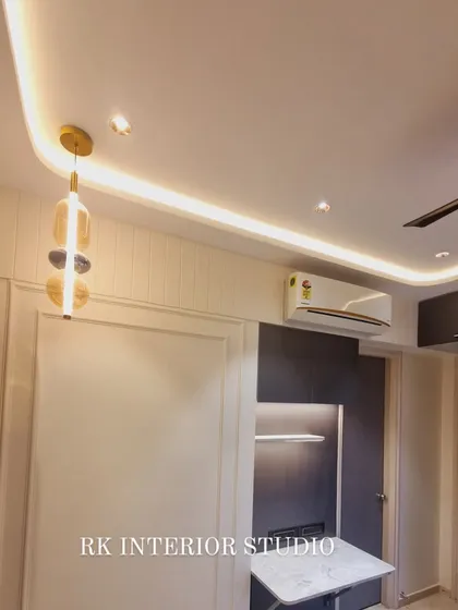 A bedroom with a compact, wall-mounted study table. The design includes overhead storage and integrated lighting, making it a perfect, space-saving workstation.
