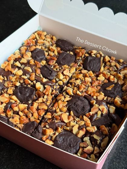A box of my popular walnut brownies, cut into neat squares and ready to be enjoyed. The combination of fudgy brownie and crunchy walnuts is a classic for a reason.