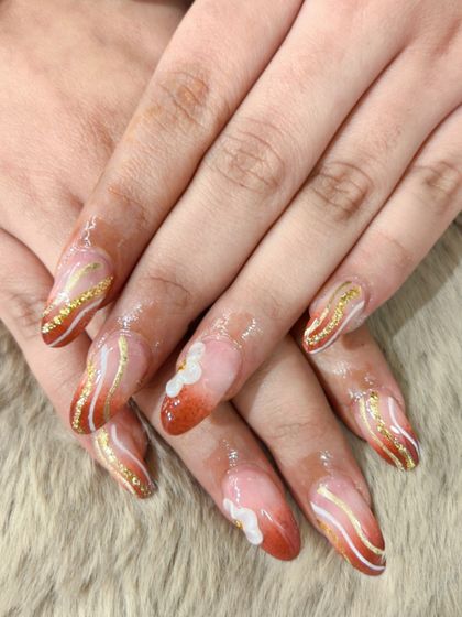 A warm, autumnal design with ombre tips and delicate gold and white swirls. The 3D flower is a perfect finishing touch.