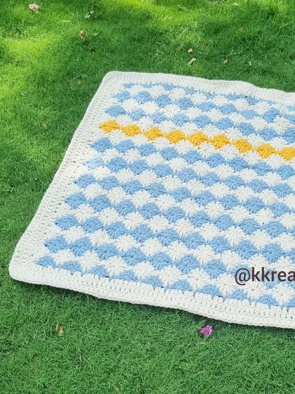 This blanket is made using a special stitch that creates a woven, checkerboard effect. It's a beautiful and timeless pattern.