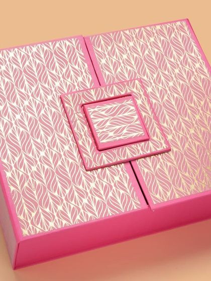 A unique, multi-level pink gift box with a metallic pattern. We use lighting to bring out foil and metallic details in packaging.