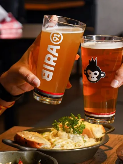 A classic "cheers" shot for Bira91. This image captures a social moment, associating the brand with friendship and good times, which is a core part of beverage marketing.