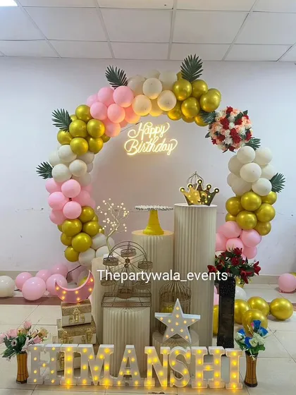 Sometimes, simple and elegant is the way to go. This beautiful ring decoration uses a soft palette of pink, white, and gold balloons, accented with a neon 'Happy Birthday' sign and light-up letters for a chic and modern celebration.
