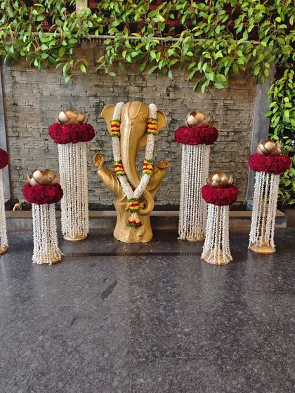 An elegant and spiritual welcome setup centered around a golden Ganesha idol. We flanked the deity with pillars of jasmine garlands and red rose arrangements, blending traditional reverence with beautiful event decor.