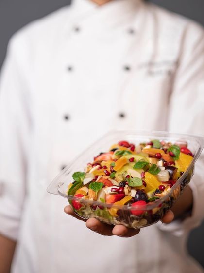 Meet our visionary founder, a culinary maestro who infuses every dish with love and patience. This image shows him holding one of our fresh fruit salad bowls.