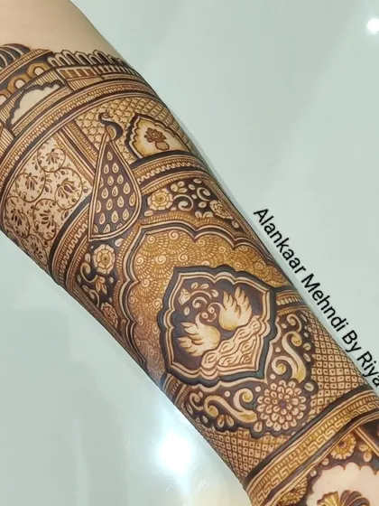 A completed arm piece featuring swans and peacocks within ornate, traditional frames.
