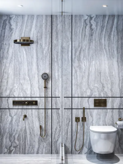 A master washroom featuring cool-toned grey marble throughout. The render focuses on the clean, linear design and the sophisticated brass fixtures.