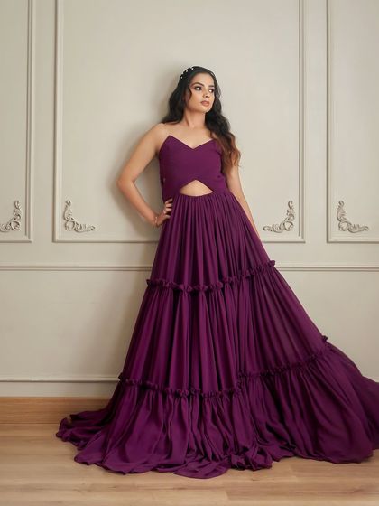 This is 'Mindy', a bold purple gown with a pleated V-neck bodice and daring waist cutouts. The three-layered skirt adds incredible volume and texture.