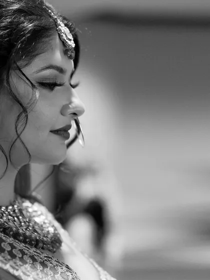 A timeless black and white profile of the bride, capturing her serene expression and the delicate details of her bridal attire.