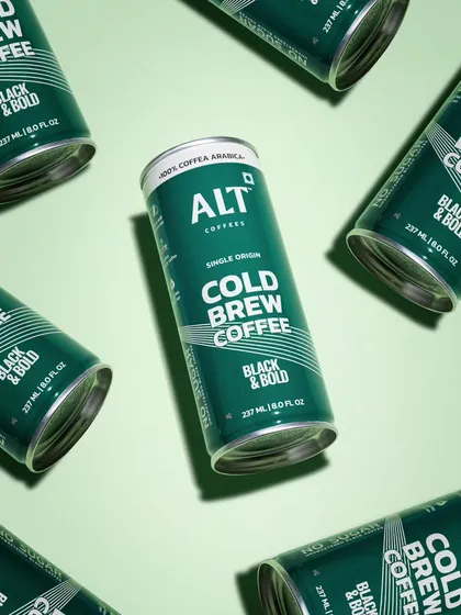 A graphic, patterned shot of cold brew coffee cans. This top-down flat lay creates a bold and modern look that emphasizes the product's sleek packaging design.