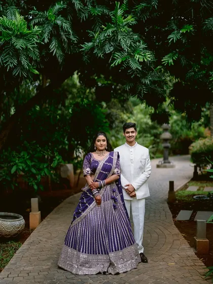 A formal portrait of Apeksha and Rutwij in a beautifully manicured garden. Their pose is classic and timeless, highlighting the elegance of their engagement attire.