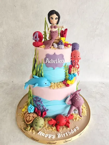 A colourful underwater world for Advika's 4th birthday. This two-tiered cake is covered in friendly sea creatures like dolphins, octopuses, and turtles, all handmade from fondant.