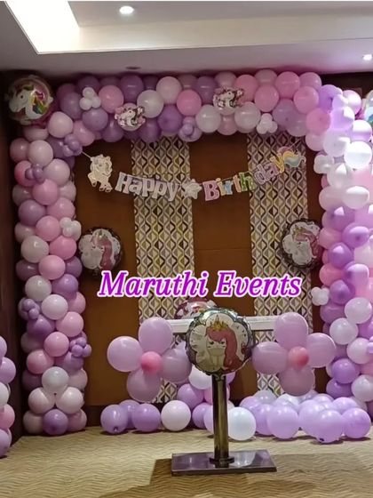 A lovely unicorn-themed party in shades of purple and pink. The full balloon arch frames a "Happy Birthday" banner, with unicorn-themed foil balloons adding a touch of magic.