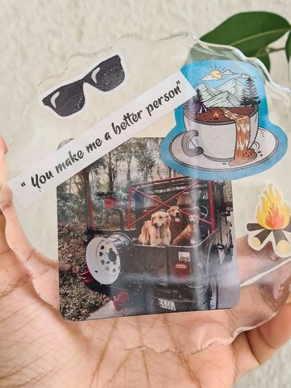 This personalized resin coaster captures a perfect memory. It includes a photo of beloved pets, a meaningful quote, and stickers that represent a love for the outdoors.