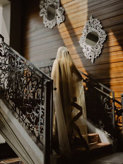 An artistic, mysterious shot of the bride walking up the stairs, her veil creating a beautiful silhouette.