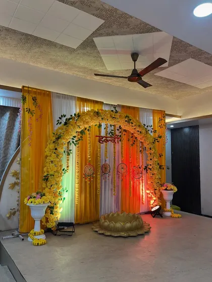 The complete Haldi setup, featuring a large arch of yellow flowers, matching drapes, and a traditional 'urli' bowl for the ceremony.
