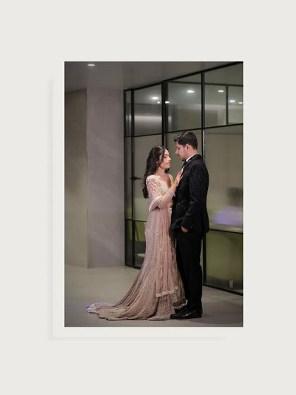 An elegant, full-length portrait from a cocktail party. The couple's classic attire and the modern interior create a timeless and sophisticated look.