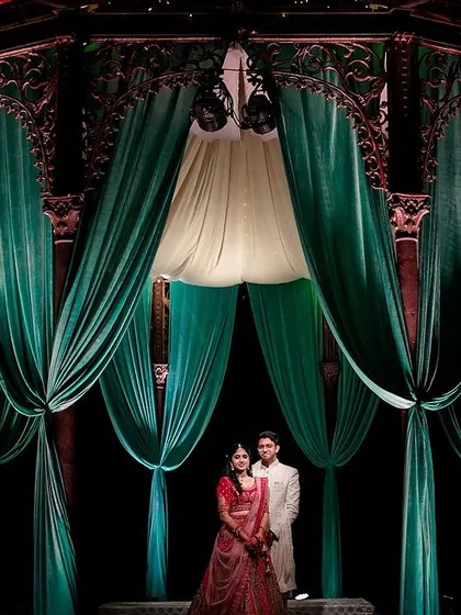 We love playing with light and scale to create dramatic, unforgettable portraits. Here, the grandeur of the decor frames the couple, making them the centerpiece of their own epic love story.