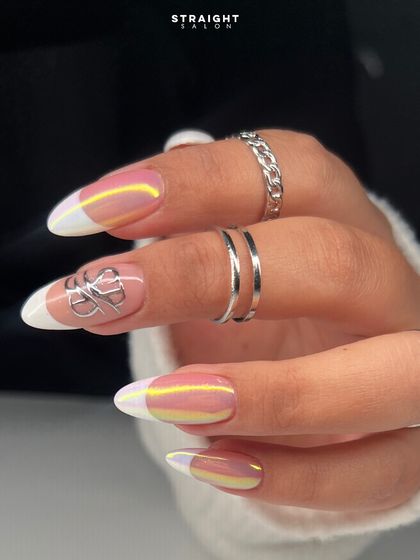 A modern French manicure with an iridescent chrome finish. The classic white tip is updated with a pearly, multi-tonal sheen and a silver chrome accent for a futuristic feel.