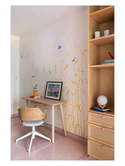 A child's study nook featuring a hand-painted mural of wheat fields and birds. This collaboration with a mural artist brings a sense of whimsy and nature into the room, making it a magical space for a young mind.