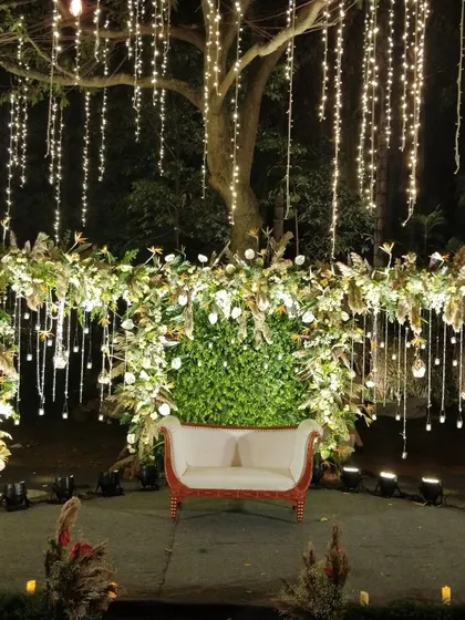 We transform outdoor spaces into enchanted wonderlands for evening receptions. Here, we used cascading fairy lights and a lush floral arch to create a magical photo backdrop, perfect for capturing memories under the stars.