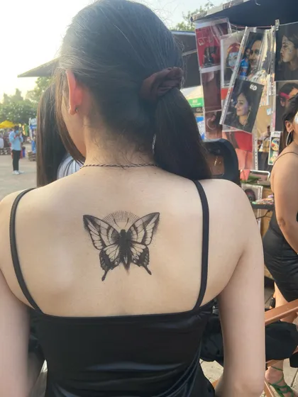 Temporary tattoos are also a big part of what I do. This black butterfly on the back is a simple, elegant, and bold statement.