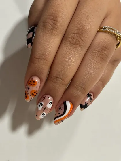 A fun and spooky set for Halloween. This design includes hand-painted ghosts, pumpkins, stars, and abstract patterns on long almond-shaped extensions.
