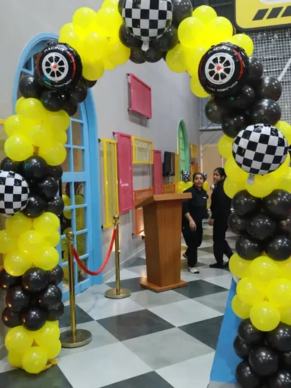 A race-themed balloon arch in black and yellow, complete with checkered flag and tire balloons. This decor instantly creates a fun, high-energy vibe.