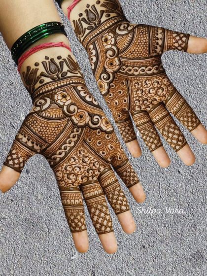 A beautiful full-hand design with intricate swirls and floral patterns, showcasing fine line work.
