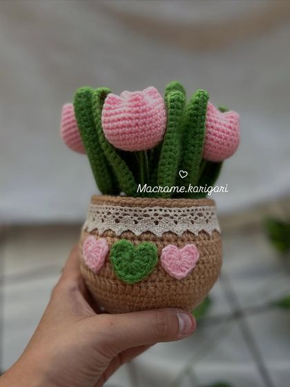 Our adorable crochet tulip pot, featuring pink tulips in a brown pot decorated with lace and tiny hearts. It's a perfect little piece of handmade charm.