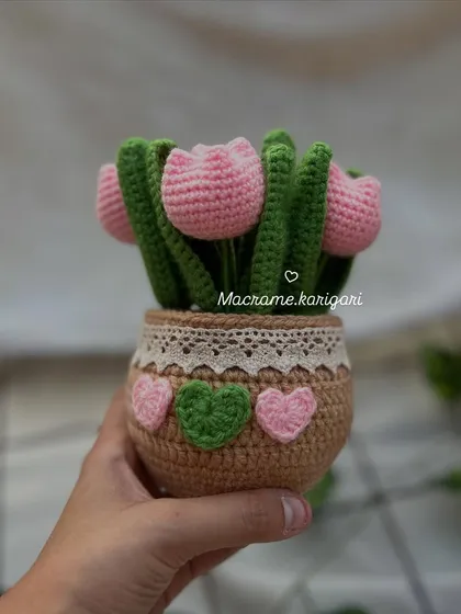 Our adorable crochet tulip pot, featuring pink tulips in a brown pot decorated with lace and tiny hearts. It's a perfect little piece of handmade charm.