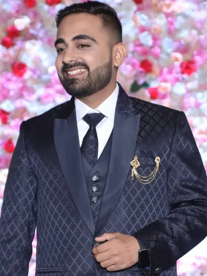 The groom looking stylish and happy. The grooming is on point, with a neat beard trim and a modern hairstyle to match his suit.