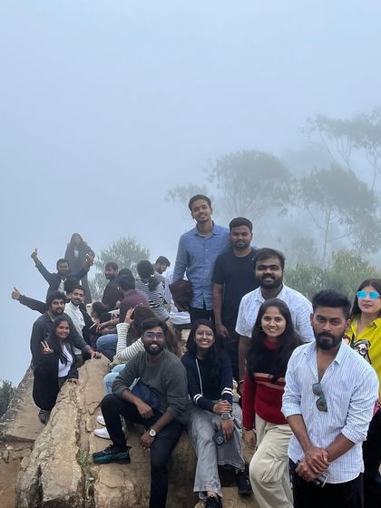 The group perched on a rock ledge, surrounded by the classic Kodaikanal mist.