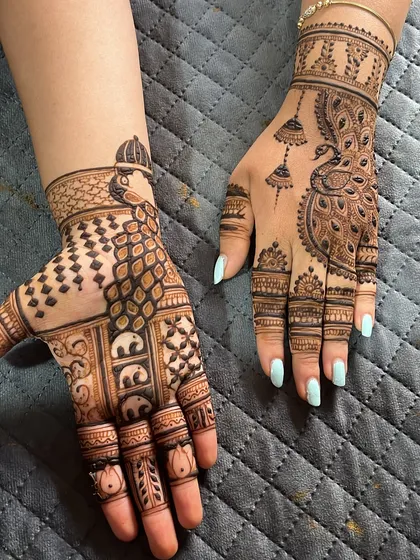 A creative mix of styles, with one hand featuring a doli and elephants, and the other a graceful peacock.