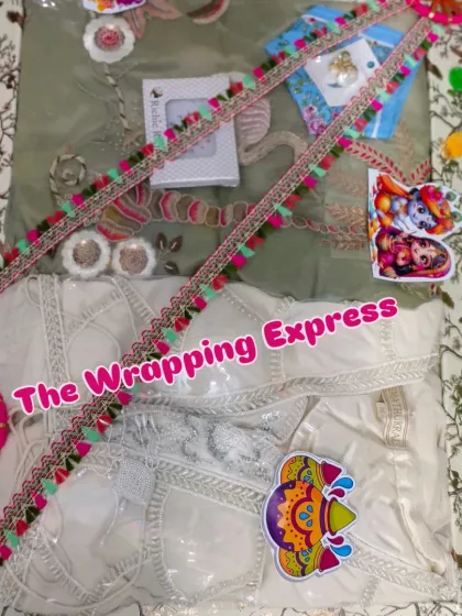 A Holi gift tray containing a beautiful white chikankari suit, decorated with colorful pom-pom lace.