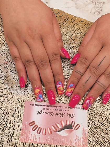 A vibrant and abstract design on coffin-shaped nails. The hot pink polish is paired with accent nails featuring a colorful, painterly pattern.