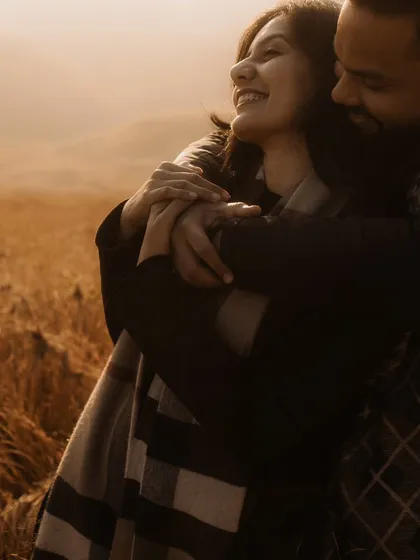 A warm and joyful embrace in a field of gold. The soft, hazy light and the bride's happy expression make this an incredibly heartwarming and candid portrait.